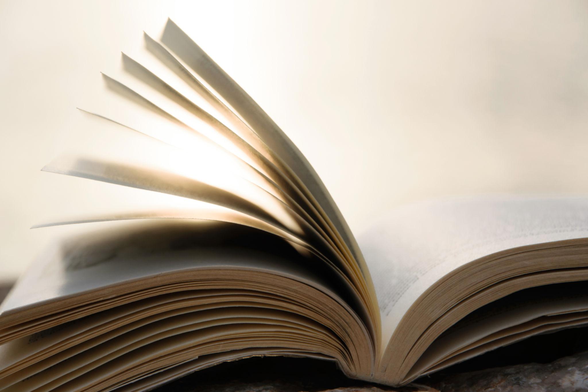 Open book in soft natural light representing the subtle, clean scent of paper in perfume