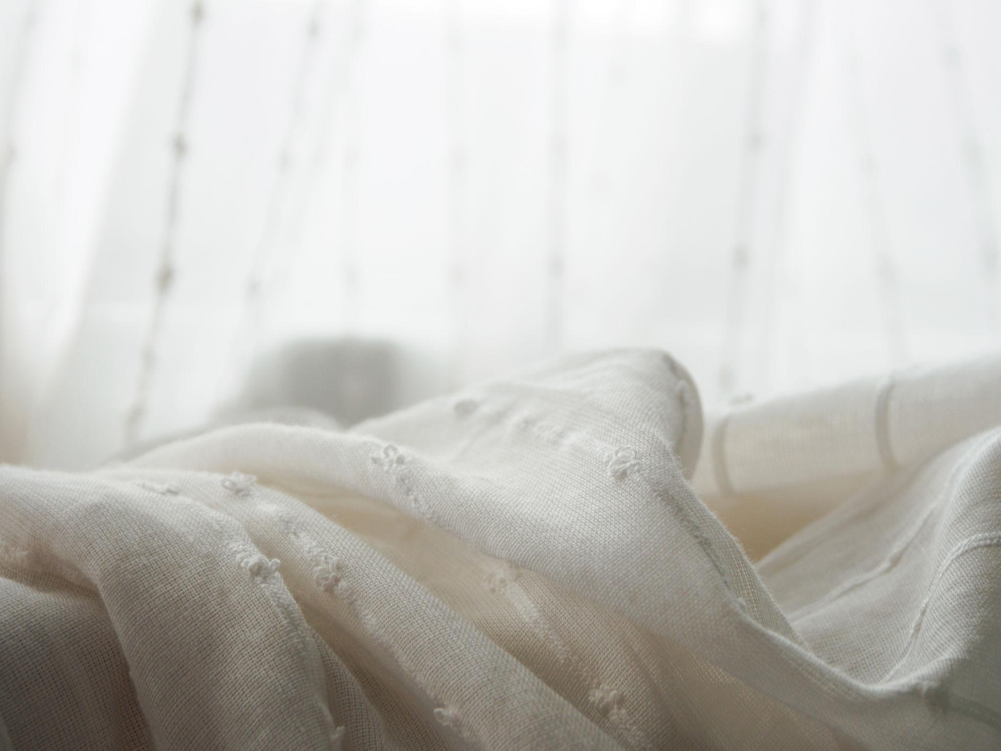 Soft light on skin and fabric representing the clean, airy feel of white musk in perfume